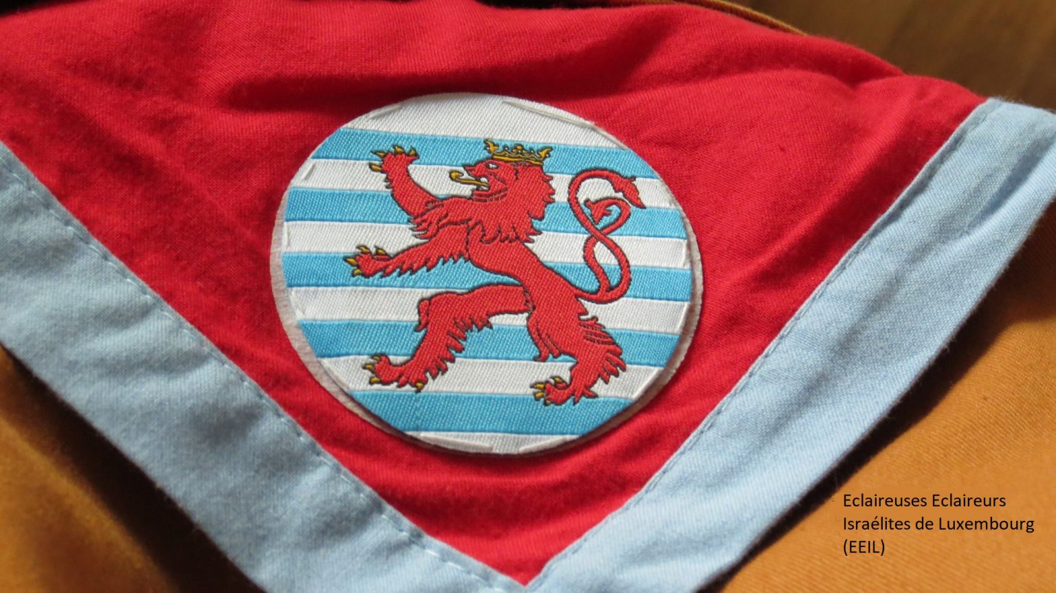 Foulard EEIL rouge à liseré bleu ciel, écusson au lion Grand-Ducal du Luxembourg